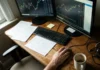 Akcie Coinbase 2026: kurz, graf a vyplatí se koupit? Pracovní stůl investora s monitory zobrazujícími grafy akcií Coinbase