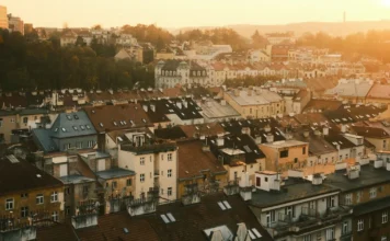 Starší betonový bytový dům se žaluzií na oknech a opotřebeným vchodem
