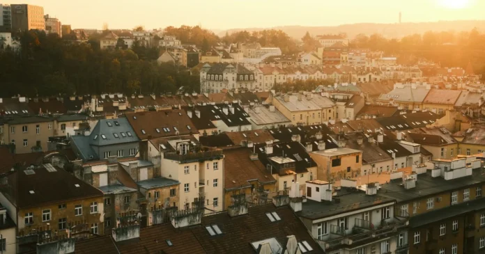 Starší betonový bytový dům se žaluzií na oknech a opotřebeným vchodem