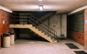 Investice do garáže a parkovacího stání: výnos a rizika Podzemní parkovací stání s jedním autem a betonovou podlahou pod fluorescenčním světlem